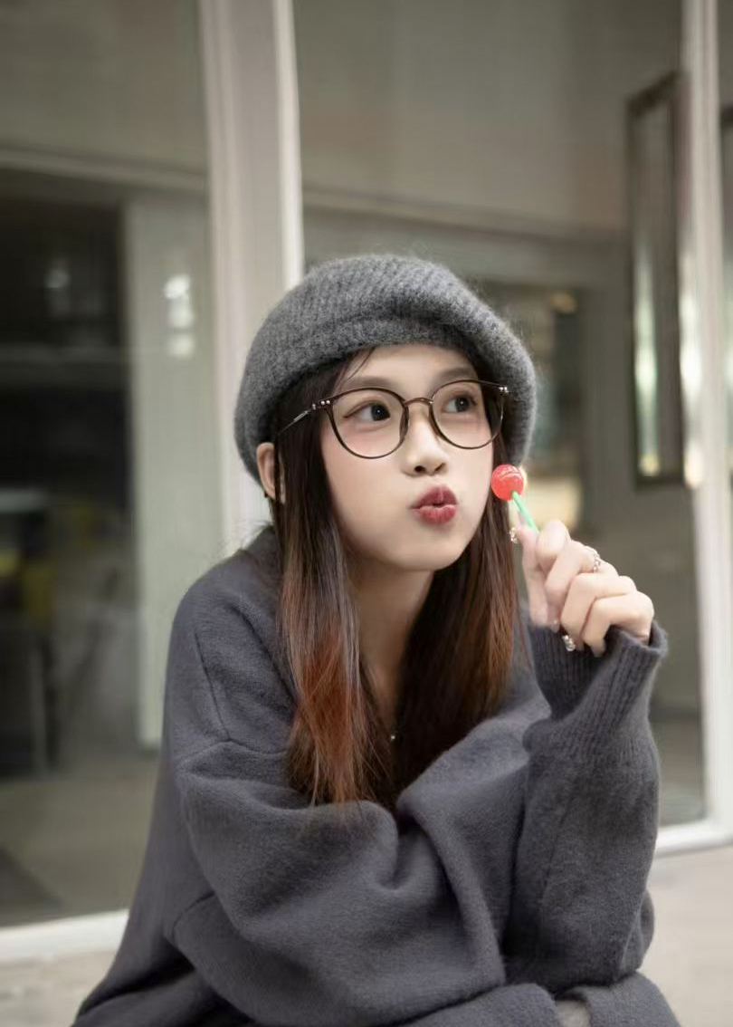 Seated portrait in a grey sweater and hat