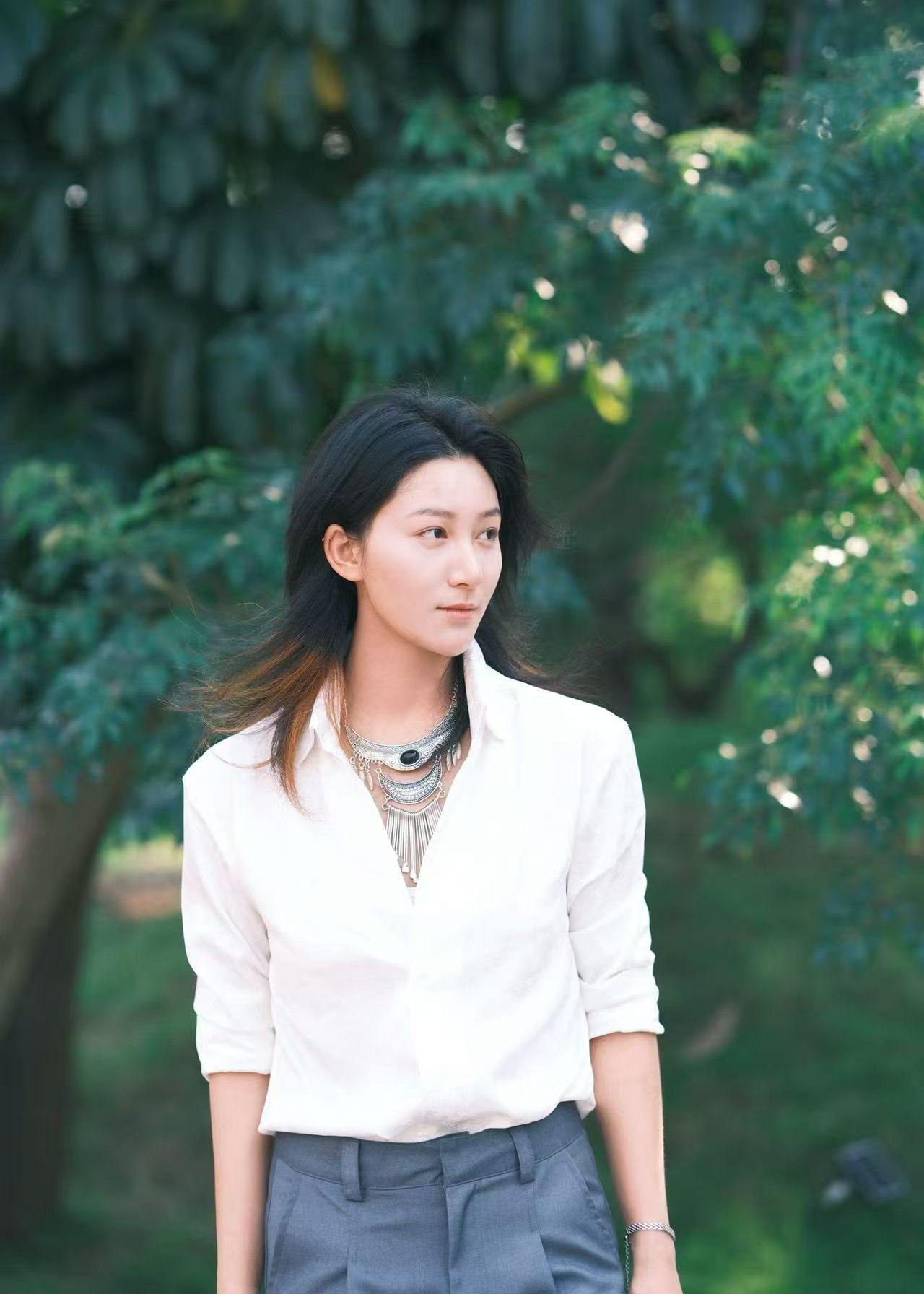 Portrait in a white shirt against greenery